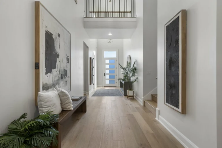 Front entrance of a home with wood floors and white painted walls 1