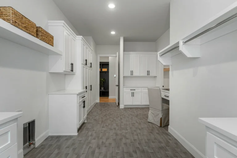 Laundry room with white painted cabinets and white walls 1